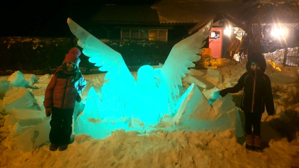 Photo of children with ice sculpture at night